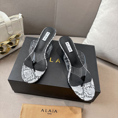 ALAIA HEELED THONG 25S 55 MM IN WHITE AND BLACK LAMBSKIN SNAKE-EMBOSSED WITH CLEAR STRAP